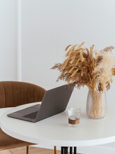 Laptop On A White Table With A Vase And An Autumn Bouquet