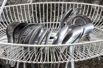 Aluminum spoons are dried in a grate drip tray hang on the wall