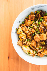 Wall Mural - healthy plant-based food, vegan noodles stir fry with broccoli peas and marinated tofu chunks