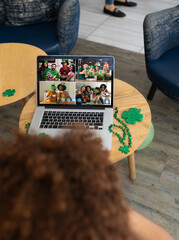 Poster - Mixed race man celebrating st patrick's day making video call to friends on laptop at a bar