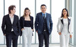 © Bangkok Click Studio - Full body shot of Millennial Asian successful professional male businessmen and female businesswomen in formal suit smiling posing look at camera walking side by side together in company hallway