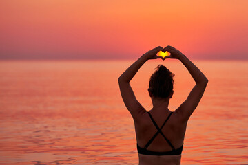 Wall Mural - Young woman swimming in the sea on sunrise