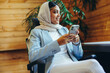 © Jacob Lund - Cheerful Muslim businesswoman using a smartphone in an office