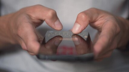 Aufkleber - Life in a smartphone. A young man looks at a mobile phone and browses social networks, close-up. Relaxed adult man reading a mobile phone application in the evening. Touch the mobile phone fingers.