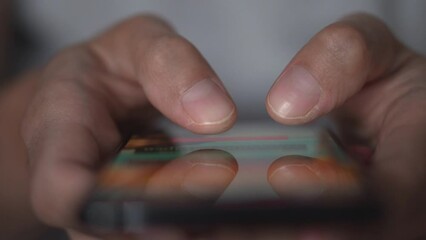 Aufkleber - Life in a smartphone. A young man looks at a mobile phone and browses social networks, close-up. Relaxed adult man reading a mobile phone application in the evening. Touch the mobile phone fingers.