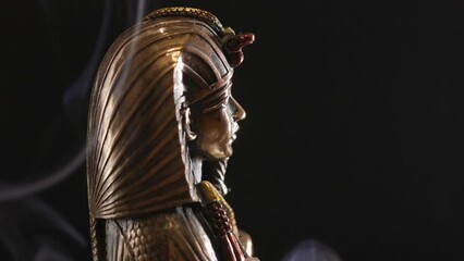 Poster - golden statue of the pharaoh in smoke on a black background