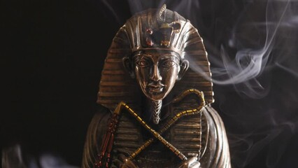 Poster - golden statue of the pharaoh in smoke on a black background