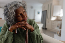 Thoughtful Senior African American Women With Cane Siting Alone In The Sunny Living Room