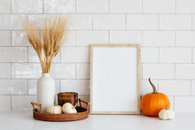 Autumn Still Life. Nordic Kitchen Interior With Picture Frame Mockup, Tray With Vase Of Dry Wheat, Candle, Pumpkins On White Table. Autumn Fall, Thanksgiving, Harvest Concept.