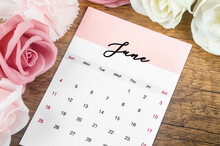 The June 2023 Monthly Calendar For 2023 Year With Pink Rose On Wooden Background.