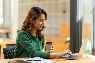 Wall Mural - Asian woman working with laptop in her office. business financial concept.