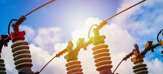 Wall Mural - Electric power transmission lines.High voltage switchgear and equipment of power plant.Blue sky white clouds summer sunlight day.Web banner,advertisement.