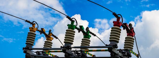 Wall Mural - Electric power transmission lines.High voltage switchgear and equipment of power plant.Blue sky white clouds summer day.Web banner,advertisement.