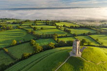 Early Morning Mists At St. Michael's Tower On Glastonbury Tor In Somerset, England