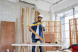 © krongthip - A male carpenter works at a table measuring the distance at the wooden planks. with carpentry equipment in the carpentry shop carpentry concept.