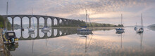 Boats Moored On The River Tiddy At Dawn Below The Victorian Viaduct At St. Germans, Cornwall, England