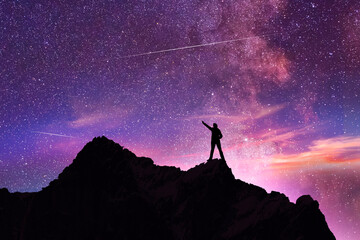Wall Mural - Hiker silhouette stands on the hill on the milky way galaxy background. Dark starry night.
