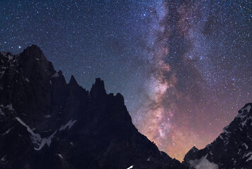 Wall Mural - Beautiful fantasy night mountains landscape. Snow covered mountains under starry sky with bright milky way galaxy. 