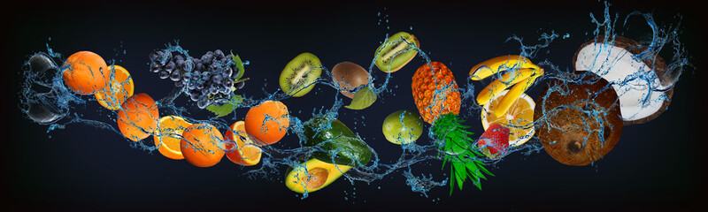 Panorama with fruits in water - juicy coconut, banana, strawberry, pineapple, lime, kiwi, avocado, orange, grapes - a delicious dessert for a festive table