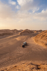 Wall Mural - Three campers in the middle of the desert at sunset. The Kalut desert in Iran is the hottest point on the planet.