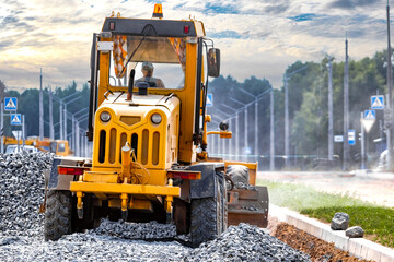 Road grader at the construction site. Powerful construction machine for ground leveling and excavation. Close-up. Professional construction equipment.