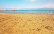Calm Day At Ein Bokek Dead Sea Beach, Blue Green Water, Sun Shade Shelter Near, Sun Shines On Sandy Beach Shore