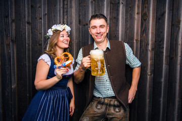 Oktoberfest, woman and man in Bavarian costume with beer mugs