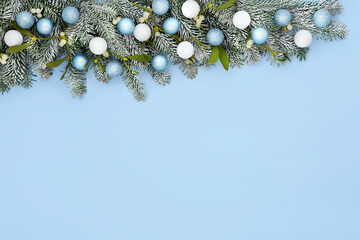 Wall Mural - Festive Christmas snow fir mistletoe tree bauble background border with white and pastel blue ball decorations. Minimal composition for winter solstice, Xmas, New Year holiday season.