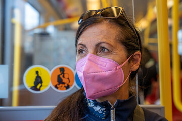 Wall Mural - Thining woman wearing a mask inside a subway train