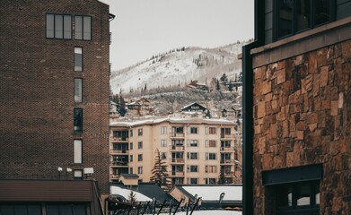 Sticker - Scenic view of buildings in town against a snowy mountain landscape background