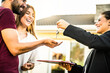 © Davide Angelini - Happy millennial couple receiving keys from realtor, purchasing real estate - Family meeting with real estate agent - New house and real estate concept