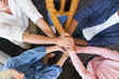 © baranq - Close up of coworkers stacking hands together at office. Business people team building concept.