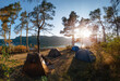 Adventures Camping tourism and tents under the view pine forest landscape near water outdoor in morning and sunset sky. Summer travel and vacation concept. The warm rays of the sun shine