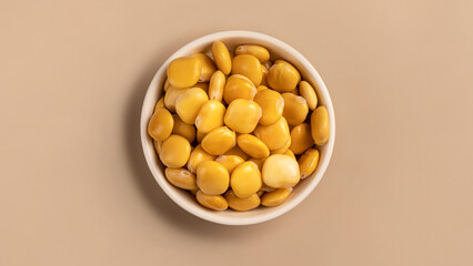 salted lupins in white bowl standing on beige background, Flay lay