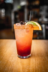 Poster - Vertical shot of a classic margarita cocktail with a slice of lime and salty rim on bar counter