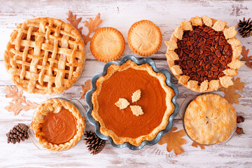 Poster - Selection of homemade autumn pies. Pumpkin, apple and pecan. Above view table scene on a white wood background.
