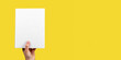© valiantsin - Banner with hand holding closed book mockup on yellow background. Reading hobby, study, learning new information concept. Space for text