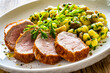 Fried pork loin with gnocchi and mushrooms on wooden table
