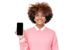 African girl in glasses holding smartphone with blank screen with copy space and showing it to viewer