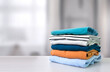 Stack of colorful clothes. Pile of clothing on table empty space background.
