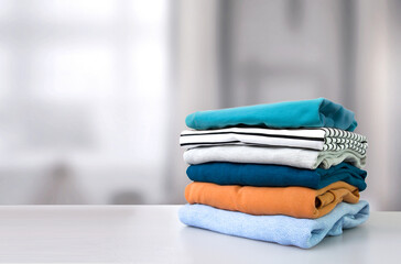 Wall Mural - Stack of colorful clothes. Pile of clothing on table empty space background.