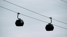 Ropeway, Cable Car Cabins Silhouettes Are Moving Against Gray Sky In Batumi, Georgia - Aerial Rope Transit, Gondola Lift - Overcast. Tourism, Cableway, Sightseeing And Public Transportation Concept