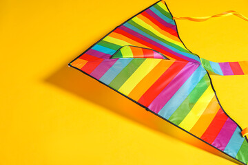 Wall Mural - Beautiful bright rainbow kite on yellow background