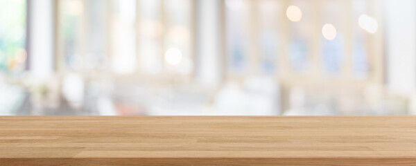 Empty wood table top and blurred coffee shop, cafe and restaurant interior background - can used for display or montage your products.