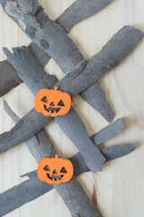 Poster - two small wooden jack o lanterns painted yellow on strips ob dry wood bark