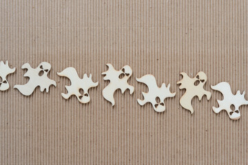 Poster - row of plain wood ghosts on corrugated brown cardboard background