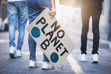 People with climate change poster or banner protest on asphalt road, street or city. Legs of group of women, walk or rally for global warming, world environment change or save the planet with flare