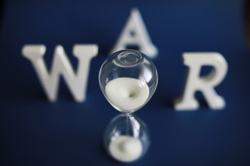 WAR, word written in wooden alphabet letters on blue background. The concept of a terrible war destroying country.