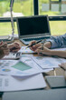 © ArLawKa - Business team working on calculators and business graph charts. financial accountant assistant Sales manager or marketer in formal attire vertical picture
