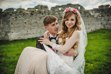 Wall Mural - The happy face bride and groom stand after wedding ceremony. A newlywed couple hugging in a country in their honeymoon. photo on nature, field, outdoors.